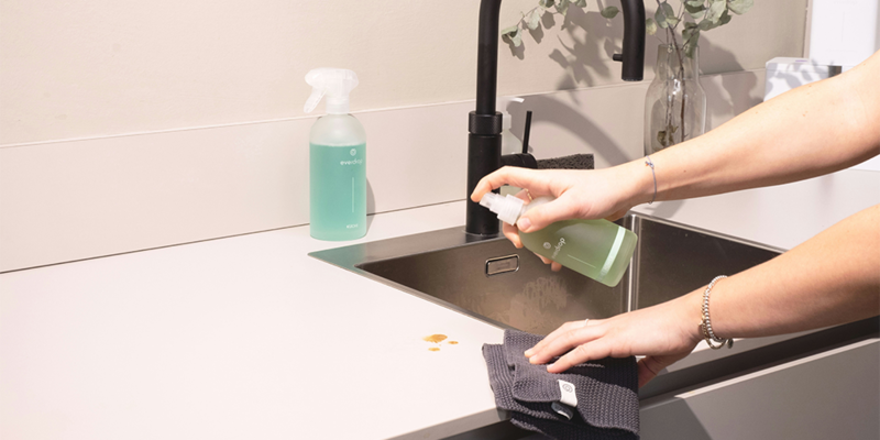 personne nettoyant sa cuisine avec un chiffon